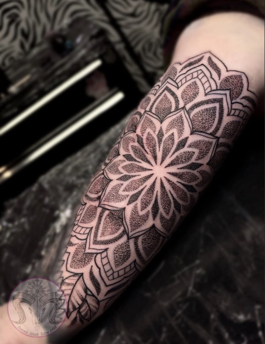 Geometric lotus mandala forearm tattoo in dotwork