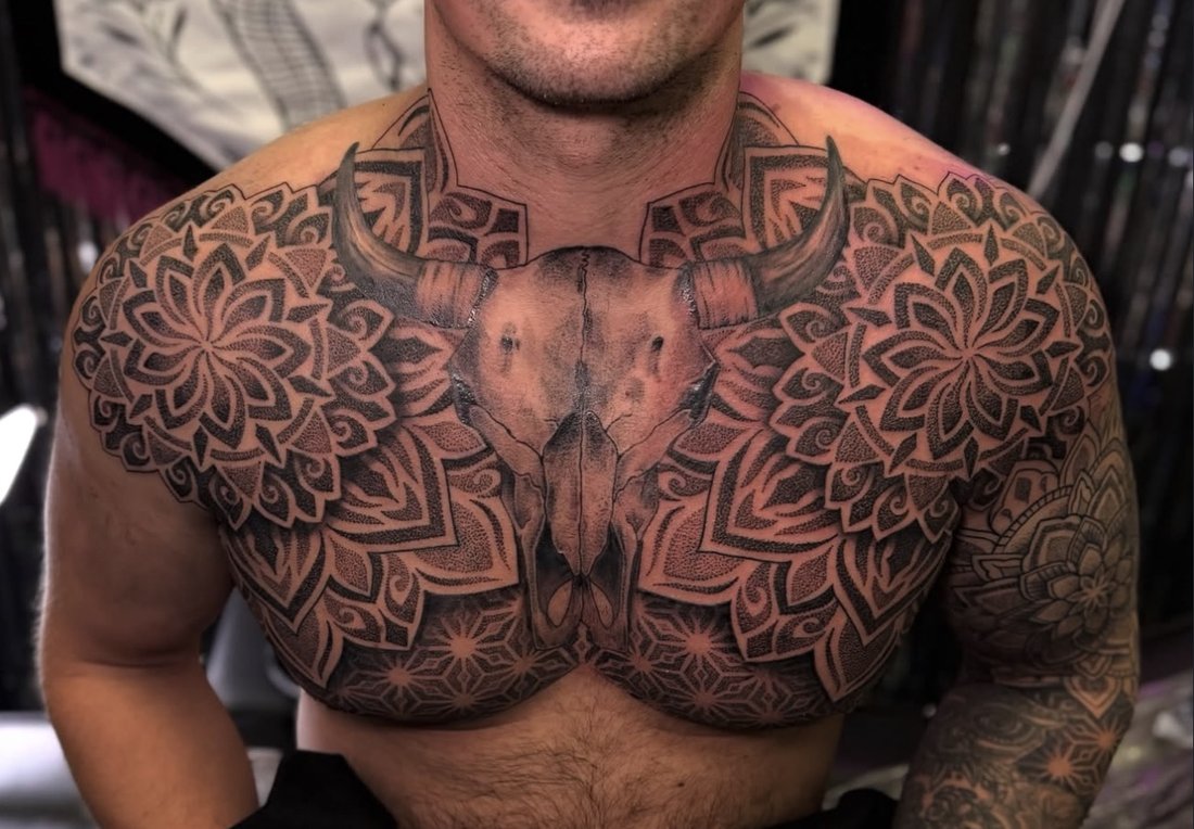 Matching dotwork mandalas across the chest with a bull skull