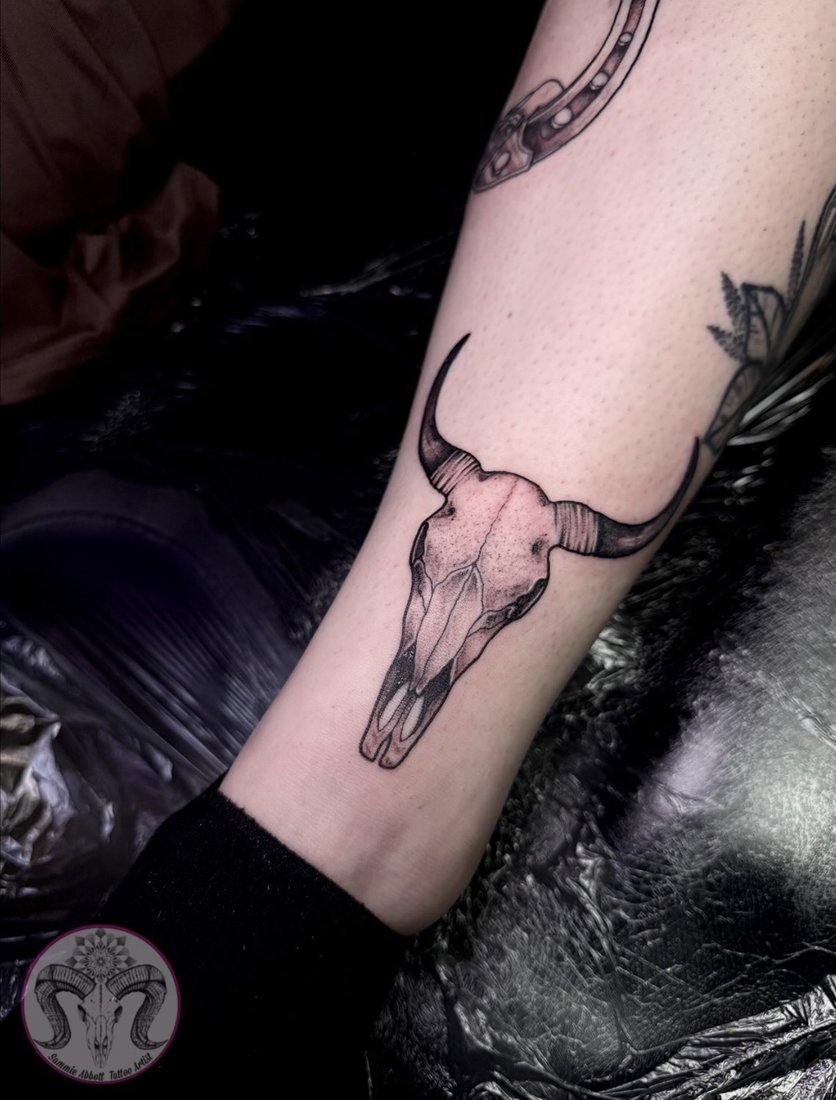 Fine line bull skull tattoo above the ankle