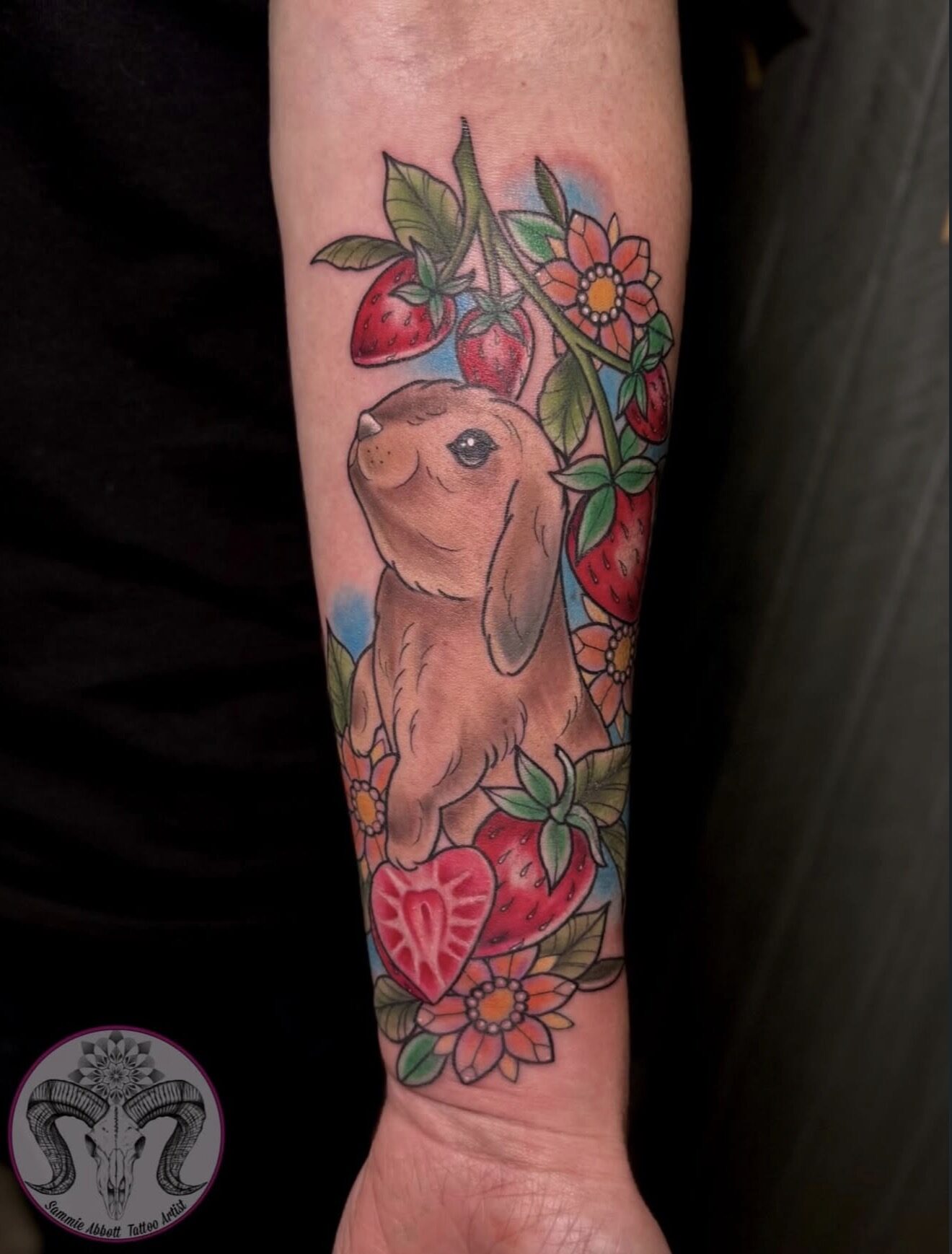 Colour rabbit among a strawberry vine on the inner forearm