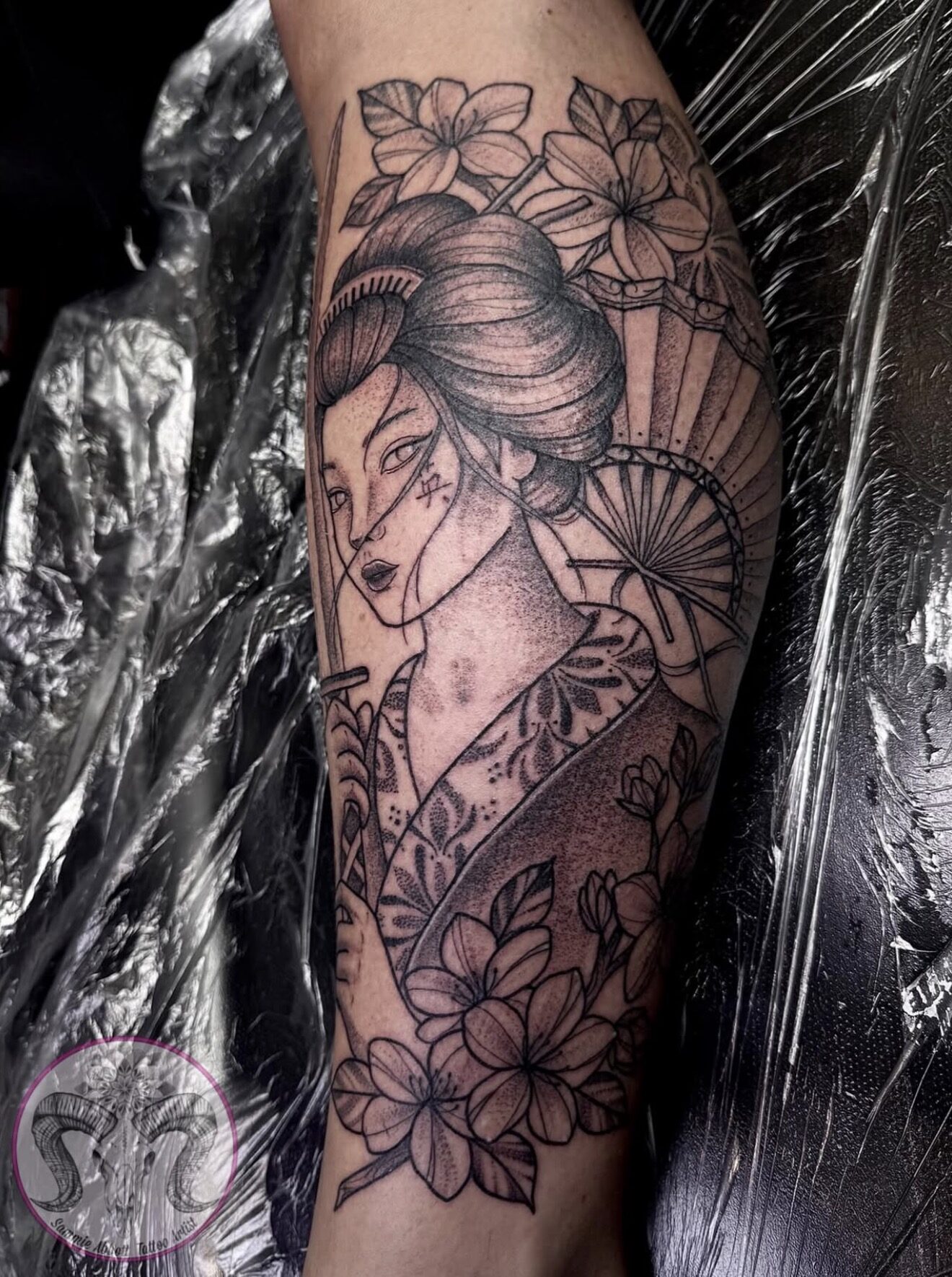 Geisha warrior with a sword and parasol among cherry blossom