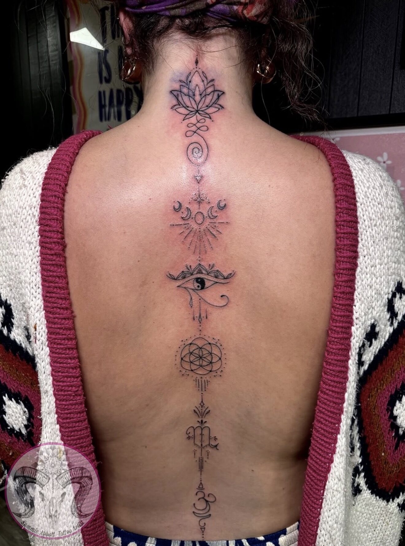 Spine tattoo of lotus, moon phases, sacred geometry and Om