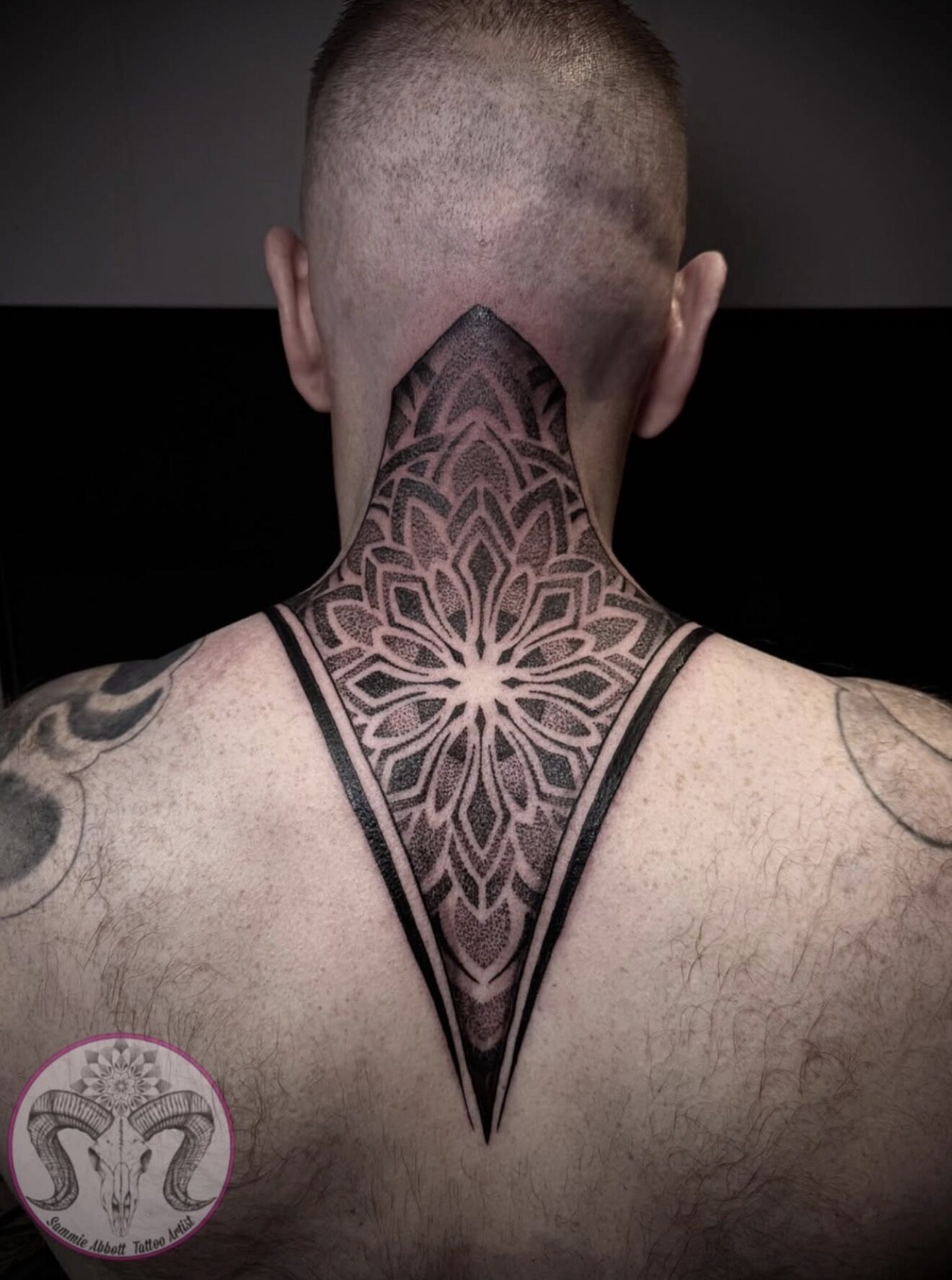 Geometric mandala inside a diamond border on the nape of the neck